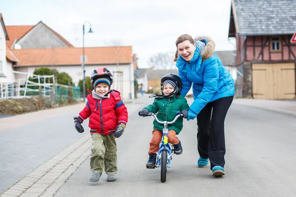 Jeune mère enseignant à son petit fils de 2 ans à faire du vélo — Photo