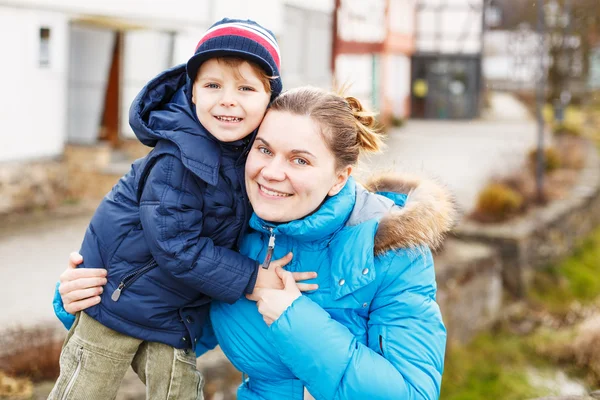 Schattig Kaukasische kleine jongen en moeder knuffelen op de brug, outd — Stockfoto