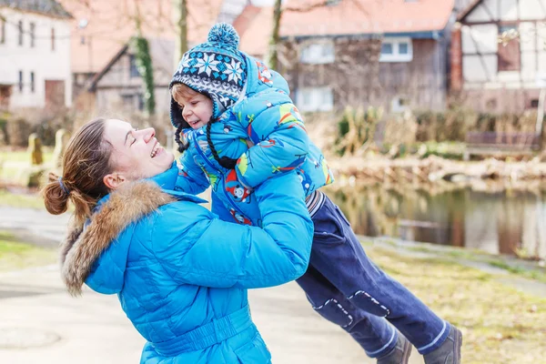 Adorable caucasian little boy and mother hugging on bridge, outd — Stock Photo, Image