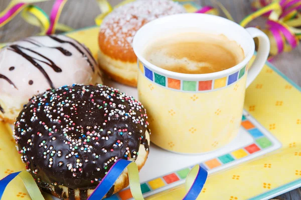 Chocolade en kokos donuts met carnaval decoratie. — Stockfoto