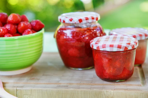 Zelfgemaakte aardbeienjam in verschillende potten en verse rijpe strawbe — Stockfoto