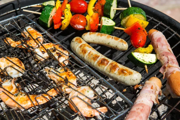 Worst, grote garnalen en plantaardige spiesjes roken op grill — Stockfoto