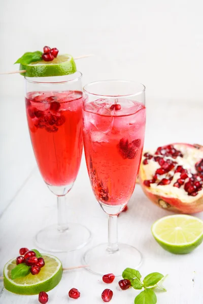 Två glas med röda pomgranate champagne, lime och mynta. — Stockfoto