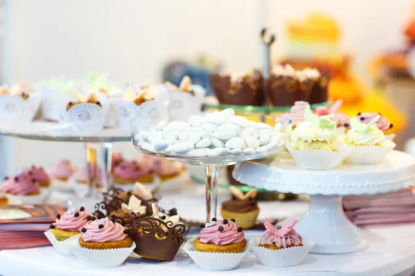 Elegante zoete tabel met cakejes, taart knalt en suikergoed op diner — Stockfoto