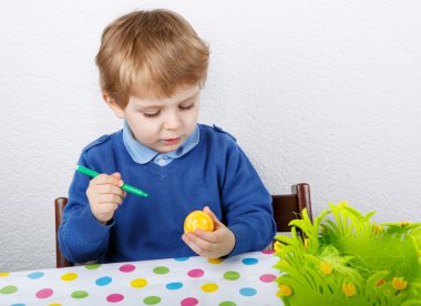 biraz yürümeye başlayan çocuk boyama geleneksel Paskalya yumurtası avı için