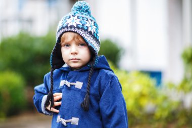 soğuk kış gününde gülümseyen şirin yürümeye başlayan çocuk portresi.