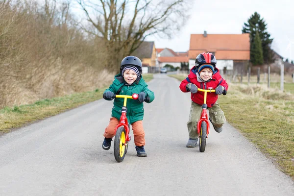 Two little twin toddler boys having fun on bicycles, outdoors — Stock Photo, Image