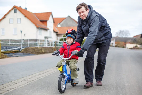 Jovem pai ensinando seu filho pequeno de 3 anos a andar de bicicleta — Fotografia de Stock