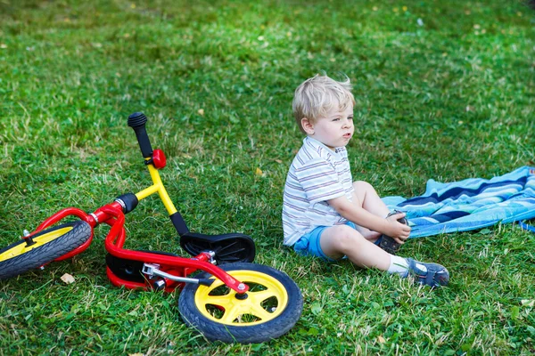 Little boy having break on green grass after riding bicycle. — Stock Photo, Image