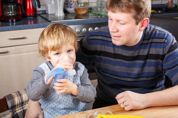 Niño y su padre haciendo inhalación con nebulizador — Foto de Stock