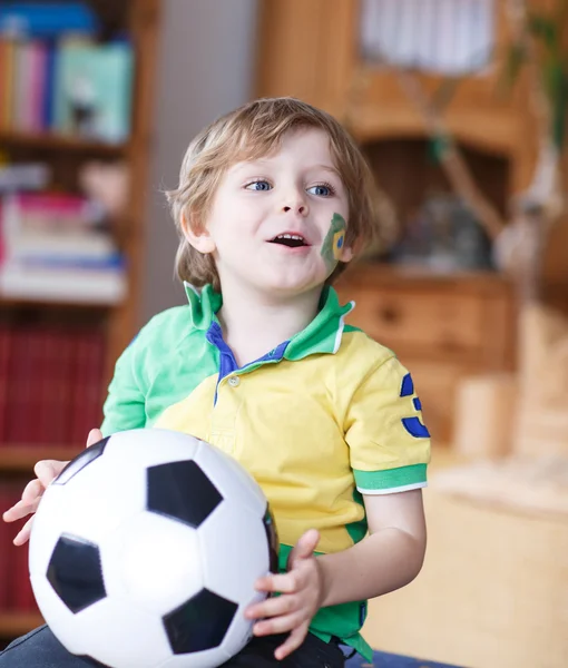 Malý blonďák školka 4 roky s fotbalovými natáčení při pohledu — Stock fotografie