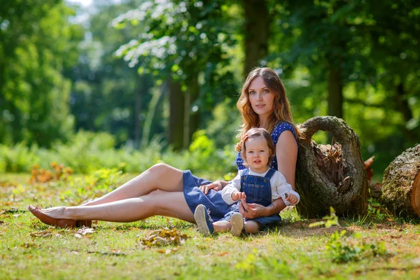 Beautiful mother and little daughter walking in summer park — Stock Photo, Image