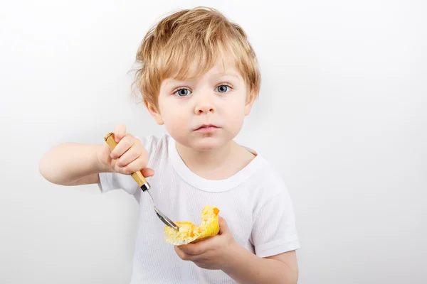 小さな男の子食べるチーズ ケーキ マフィン. — ストック写真