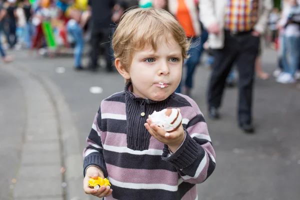 Jongetje van drie jaar eten op een kermis, buitenshuis — Stockfoto