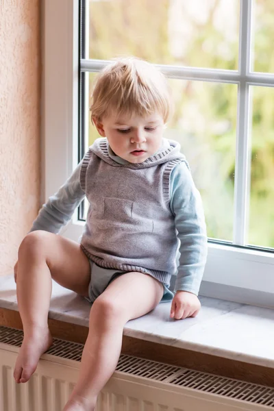 Bedårande barn pojke tittar ut genom fönstret — Stockfoto