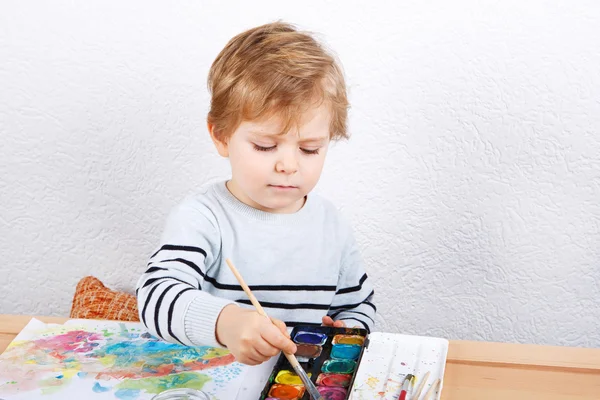 Милый двухлетний мальчик, развлекающийся живописью. — стоковое фото