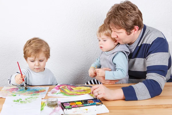 Padre y dos hermanos pequeños que se divierten pintando — Foto de Stock