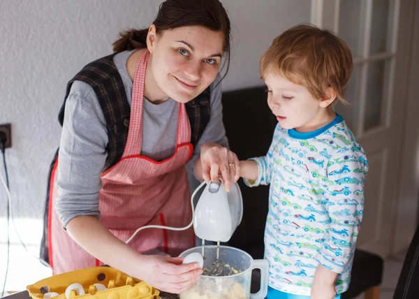 Petit garçon tout-petit et sa mère s'amusent avec la cuisson à la maison — Photo