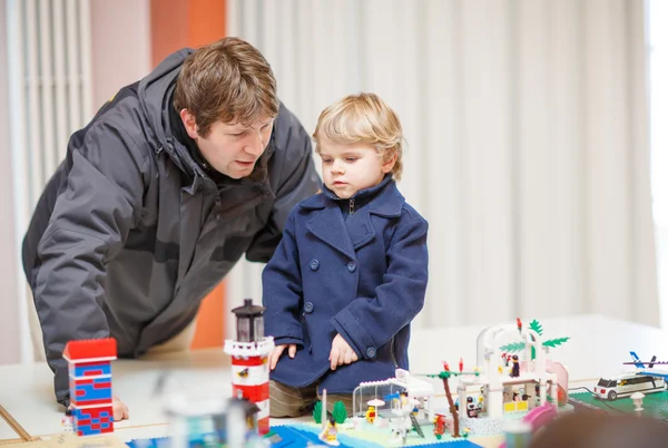 Père et petit fils s'amusent sur l'exposition de jouets, à l'intérieur . — Photo