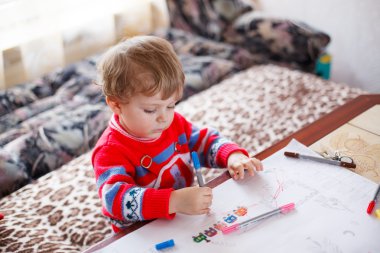 yürümeye başlayan çocuk renkli kalemler ile çizim