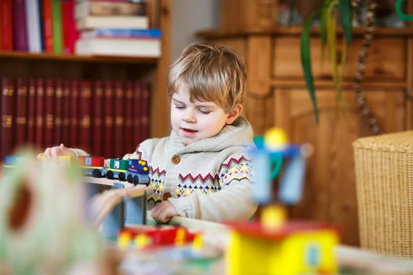 Piccolo bambino che gioca con la ferrovia di legno, in casa — Foto Stock