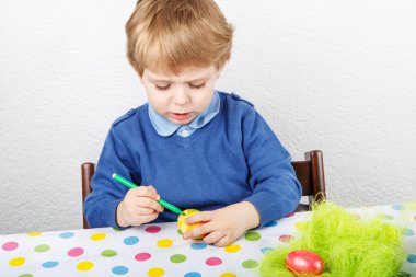 biraz yürümeye başlayan çocuk boyama renkli yumurta Paskalya için AVI
