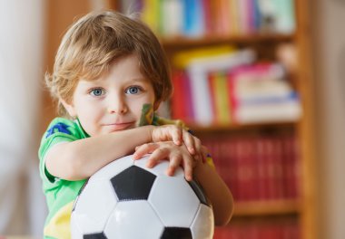 küçük çocuk televizyonda Futbol Kupası maç izlerken.