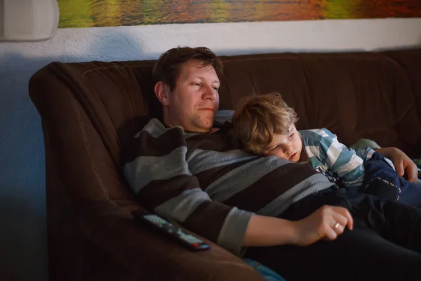 可爱的小男孩和他的父亲看电视、 在室内在黑暗的房间里，在晚上 — 图库照片