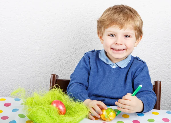 Kleine peuter jongen schilderij kleurrijke eieren voor Pasen jagen — Stockfoto