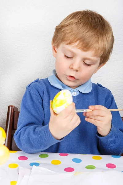 Kleine peuter jongen schilderij kleurrijke eieren voor Pasen jagen — Stockfoto