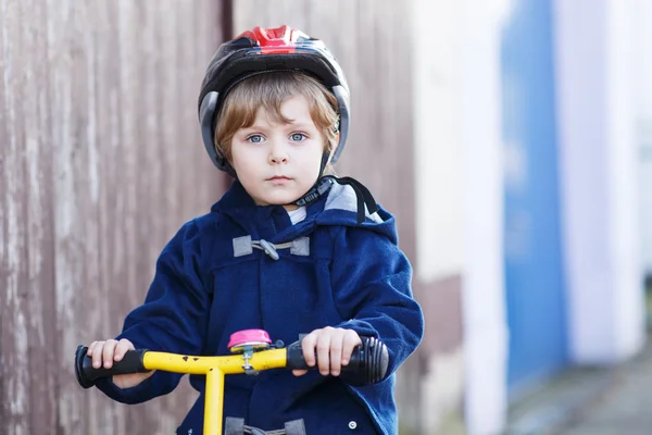 Niño pequeño montando en bicicleta en el pueblo o la ciudad — Foto de Stock