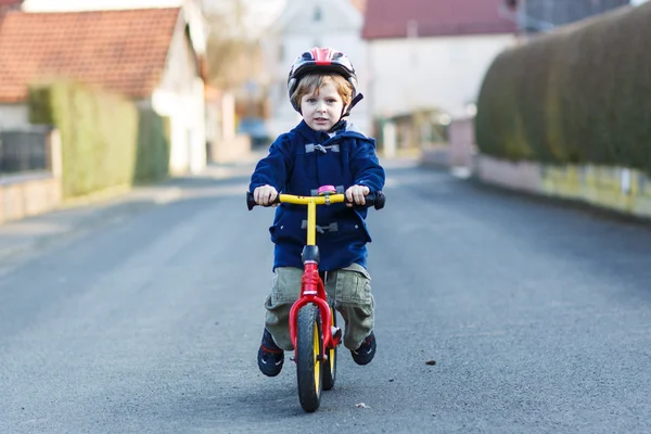 Malý kluk jedoucí na kole v obci nebo městě — Stock fotografie