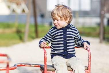 yürümeye başlayan çocuk açık playgro eski carousel eğleniyor