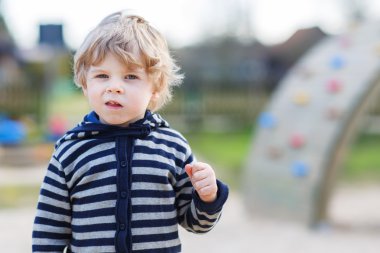 Dışarıdaki çocuk bahçesinde eğlenen küçük çocuğun portresi