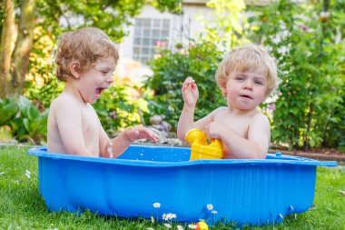 İki kardeş çocukları yaz aylarında su ile eğleniyor