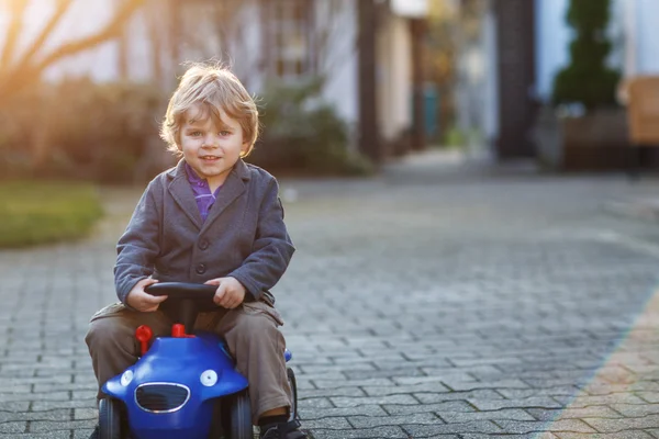 Little boy driving big toy car, outdoors — Stock Photo, Image
