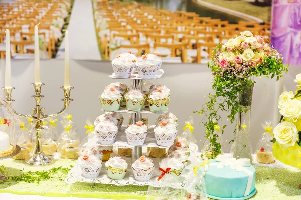 Wedding cake and cupcakes on event or reception party.
