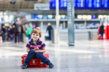 Little boy going on vacations trip with suitcase at airport clipart
