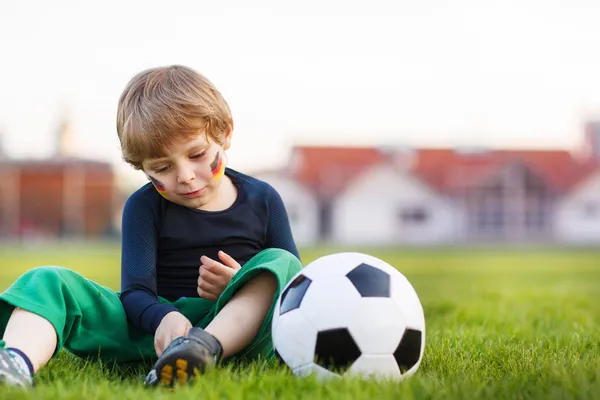 Blond boy of 4 playing soccer with football on football field — Stock Photo, Image