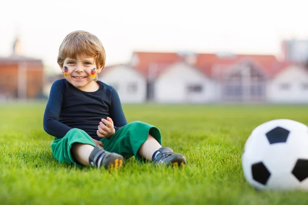 Niño rubio de 4 jugando al fútbol con el fútbol en el campo de fútbol —  Fotos de Stock