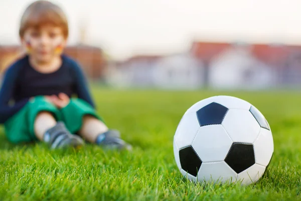 Voetbal en kleine jongen op achtergrond — Stockfoto