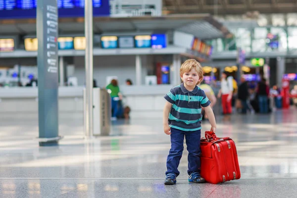 小さな男の子の空港でスーツケースの休暇旅行に行く — ストック写真