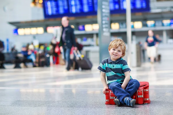 Malý chlapec na dovolenou výlet s kufrem na letišti — Stock fotografie