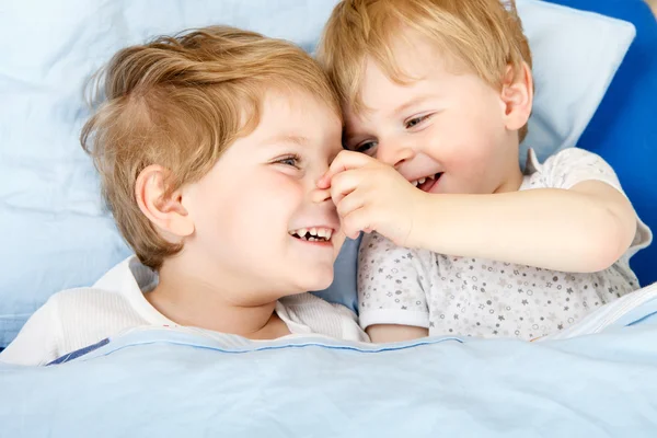 Kleine broer of zus jongens plezier in bed thuis — Stockfoto