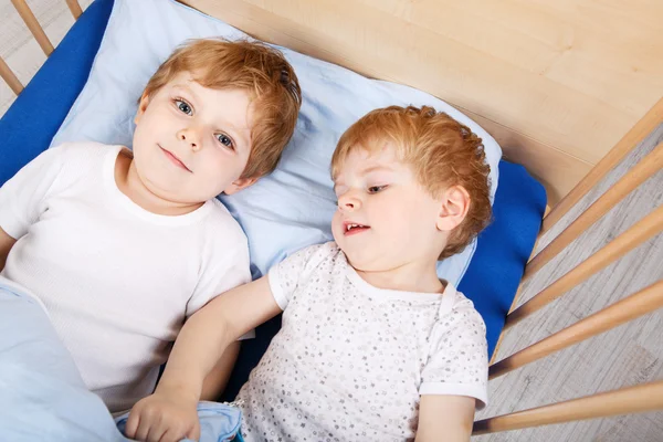 Små syskon pojkar har roligt i sängen hemma — Stockfoto