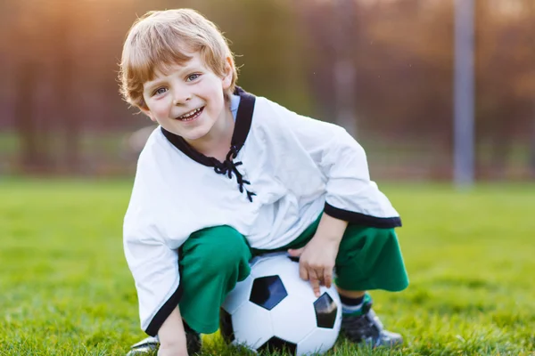 Niño rubio de 4 jugando al fútbol con el fútbol en el campo de fútbol —  Fotos de Stock