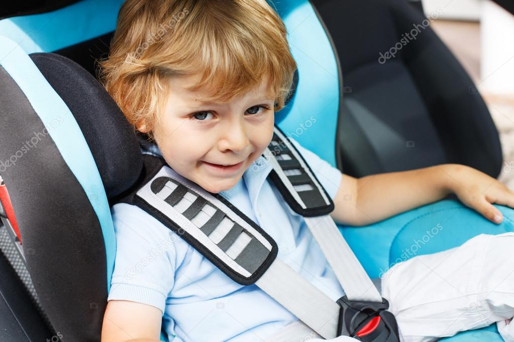 Little boy of 3 years sitting in safety car seat.