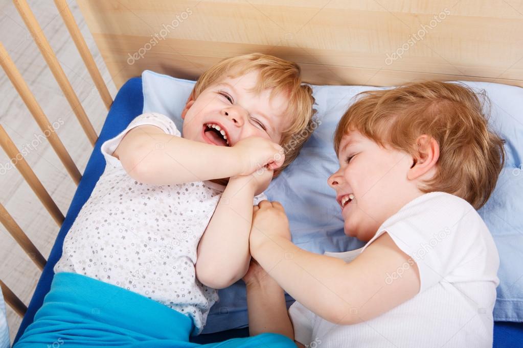 Two little toddler boys having fun and fighting 