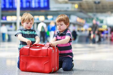 Two brother boys going on vacations trip at airport clipart