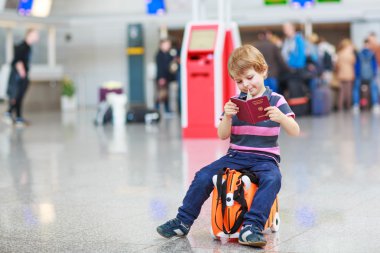 Little boy going on vacations trip with suitcase at airport clipart